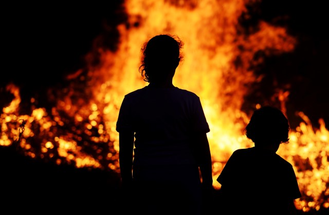 Two children looking at big fire